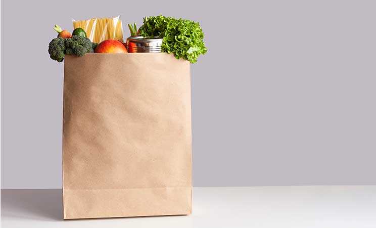 Brown paper grocery bag full of various groceries